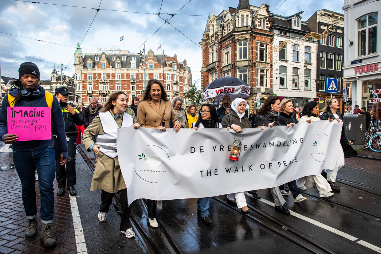 Een groep mensen met een spandoek die protesteren tijdens de vredenswandeling in Amsterdam